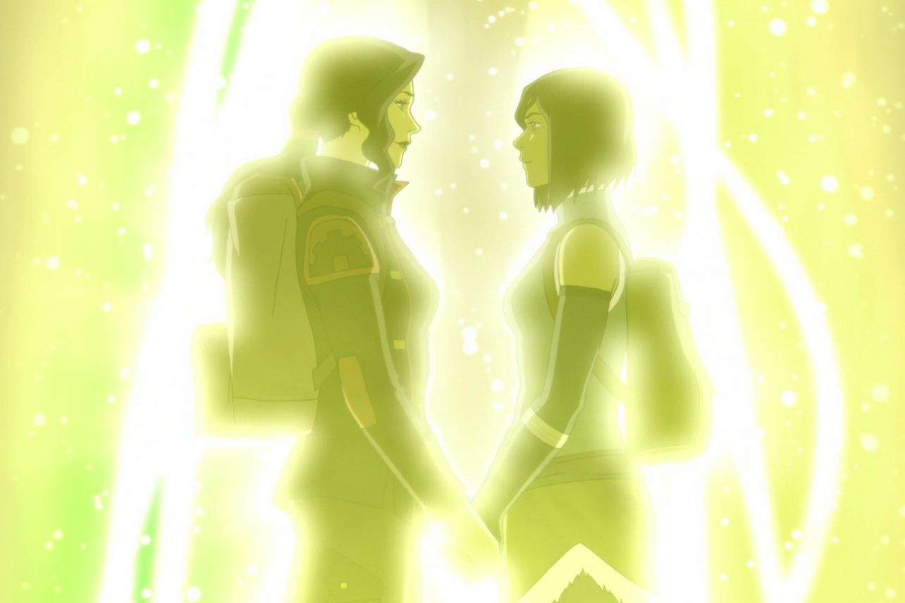 A screenshot from the final scene of The Legend of Korra. Korra and Asami stand facing each other, holding hands, and gazing into each other's eyes. They are back lit by a yellow spirit portal, which envelops them in a yellow glow.